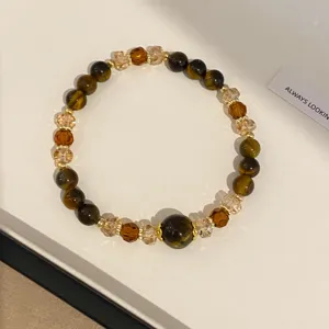 Detailed close-up of a vintage retro tiger eye stone and brown crystal beaded bracelet.