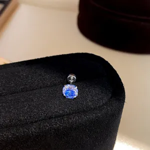 Close-up detail shot of a dazzling blue zircon screw back ear stud, glittering elegantly.
