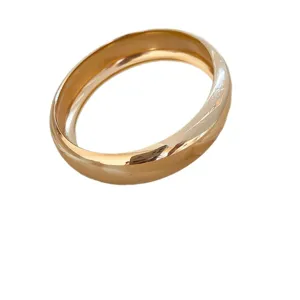 Pulsera de brazalete redondo liso chapado en oro minimalista para uso diario elegante.