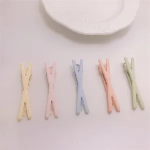 Colorful X-shaped duckbill hair clips with soft rubber paint finish, cute kids hair styling.
