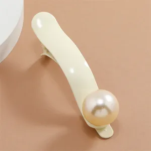 Exquisite detail view of the curved cream white hair clip featuring a large glossy imitation pearl accent.