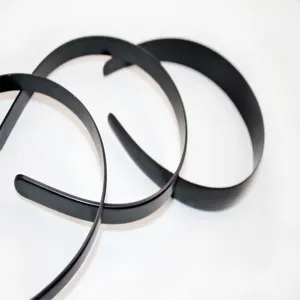 Close up detail of minimalist black headband accessories, featuring a sleek design for daily use.
