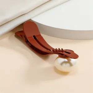 Detailed view of the elegant brown hair clip featuring a large faux pearl for women's daily styling.
