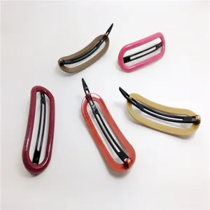 Detailed shot of multi-color hollow geometric hair clips showing plastic frame and clip.