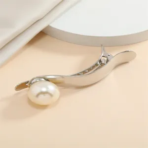 Close-up detail of elegant silver metal hair clip adorned with large pearl for women.