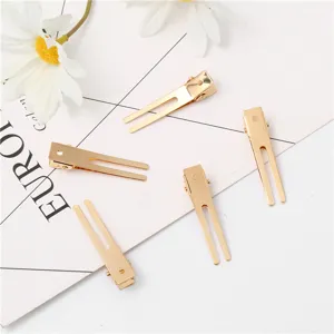 Gouden haarspelden met dubbele tanden detailopname, metalen eendebek speldjes voor haarstyling.
