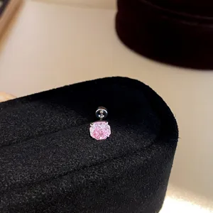 Detailed view of a stylish pink cubic zirconia screw-back stud earring on black velvet display.