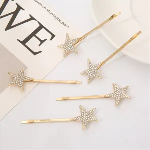 Vista detallada de horquillas doradas con estrella de diamantes de imitación para flequillo.