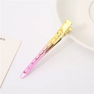 Gradient colored metal duckbill hair clip with cutout design, sectioning styling tool detail.