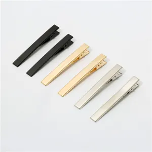 Detail view of metal duckbill hair clips in assorted colors including black, gold and silver.