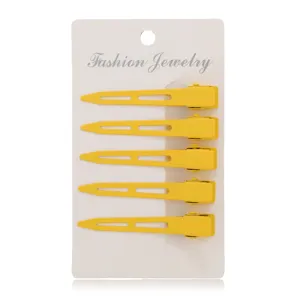 Set of 5 yellow metal duckbill hair clips with cutout design on display card for kids.