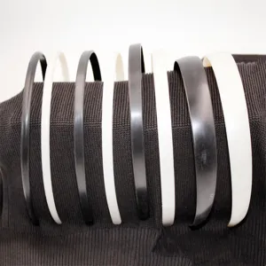 Detail shot showcasing black and white plastic headbands neatly arranged for daily wear.