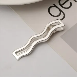 Detailed close-up shot showcasing the sleek texture and design of this silver wavy metal hair clip.