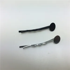 Primo piano dettagliato di accessori per fermagli fai da te, forcine in metallo con basi rotonde piatte.