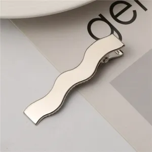Detailed close-up of a sleek silver wavy metal duckbill hair clip, perfect fashion accessory.