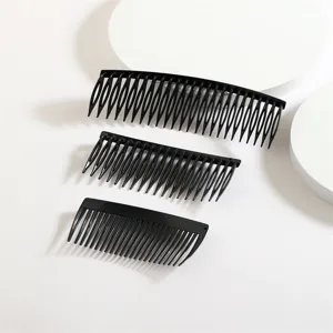 Vue de détail de peignes à cheveux noirs en plastique de différentes tailles, agencement soigné.