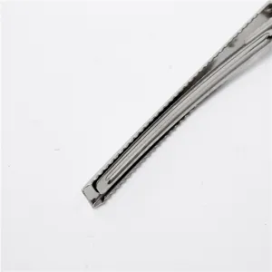 Dettaglio molletta per capelli a becco d'anatra in metallo argentato, bordo dentato.