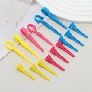 Colorful plastic hair sectioning clips detail shot, professional styling duckbill clips for salon use.