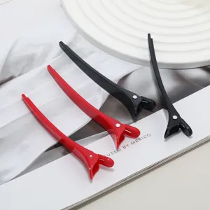 Detailed view of 11.5cm black and red hair sectioning duckbill clips for salon styling.