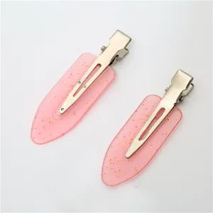 Close-up details of pink candy color seamless hair clip with gold glitter, makeup duckbill clip.