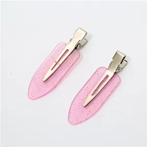 Pink glitter hair clip detail showing sparkling gold powder on smooth resin duckbill design.