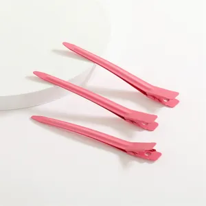Lot de trois pinces à cheveux bec de canard en aluminium rose pour coiffure professionnelle.