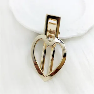 Gold hollow heart hair clip for women, stylish DIY metallic barrette accessory detail.