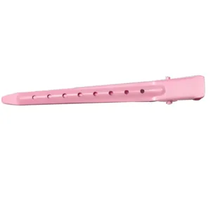 Close-up detail of pink metal hair duckbill clip with ventilation holes for styling