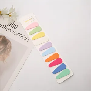 Dettaglio di forcine colorate che mostrano vivaci mollette a scatto su cartoncino.