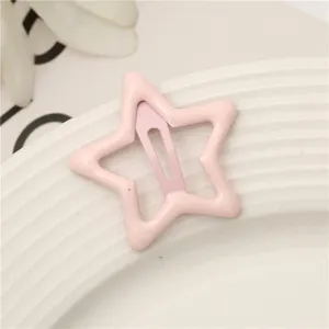 Detalle de primer plano de linda horquilla de estrella rosa, clip metálico color caramelo.