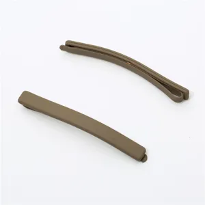 Matte brown hair clip detail, minimalist bobby pin close up showing smooth frosted texture.