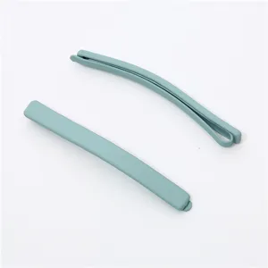 Close-up detail of minimalist matte hair clip, smooth texture, elegant light blue color.
