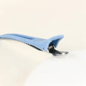 Detailed view of blue speckled duckbill hair clip, professional salon styling tool for parting.