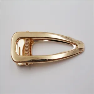 Gedetailleerd aanzicht van gouden holle haarclip, met metalen textuur en stevig veermechanisme.