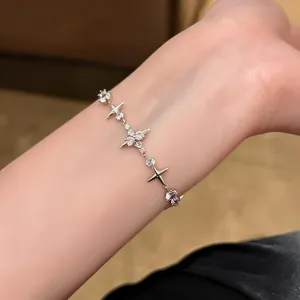 Primer plano detallado de la pulsera con dijes de estrella de circón en la muñeca.