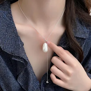 Dettaglio ravvicinato di una collana con ciondolo in perla barocca irregolare argento.
