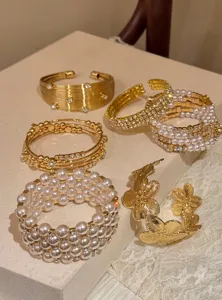 Ensemble de bracelets empilables perles dorées vintage, détails bijoux manchette strass.
