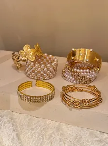 Gros plan de bracelets superposés dorés vintage avec perles, design élégant et raffiné.