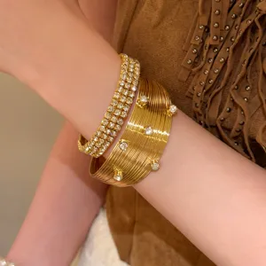 Vue détaillée du bracelet manchette doré vintage à multicouches et strass brillants.