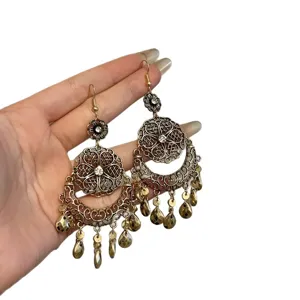 Vintage ethnic style dangle earrings with flower and teardrop tassels. Elegant gold-toned design.
