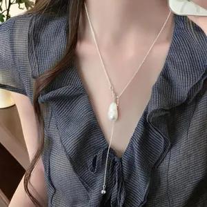 Primo piano dettagliato dell'elegante collana di perle a Y con delicata catena in argento.