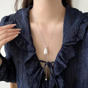 Dettaglio collana in argento a Y con ciondolo di perla barocca dal design elegante.