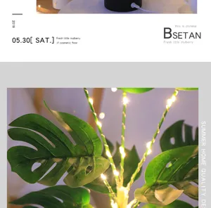 Primer plano de hojas de monstera artificiales con luces LED para una decoración acogedora.