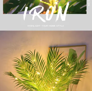 Vista detallada de lámpara nocturna LED de planta artificial con luces cálidas para decoración.