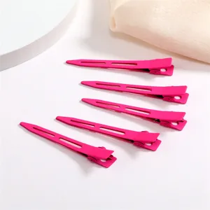 Detailed view of candy pink metal duckbill hair clips, stylish single prong clips for cute styling.