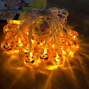 Halloween LED Kürbis Lichterkette Detailansicht mit warm leuchtenden orangen Lichtern auf dem Tisch.