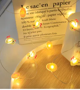 Primo piano dettagliato di luci a LED pasquali con simpatici pulcini e uova luminosi sul vassoio.