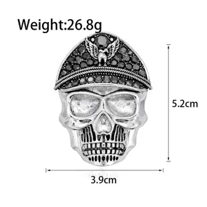 Detailed silver-tone skull brooch featuring a military-style peaked cap with black rhinestones.