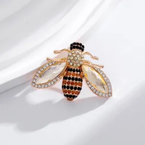 Gros plan détaillé de la broche abeille en cristal de luxe, strass étincoyants et métal doré.