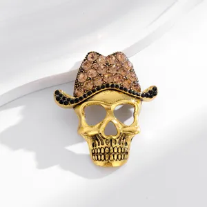 Detailed view of vintage gold skull brooch with sparkling brown and black rhinestone cowboy hat.